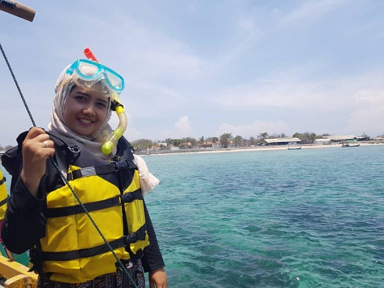 Foto di atas kapal dengan latar belakang Pulau Gili Ketapang. Peralatan keamanan (safety) keren lengkap siap untuk terjun ke terumbu karang.